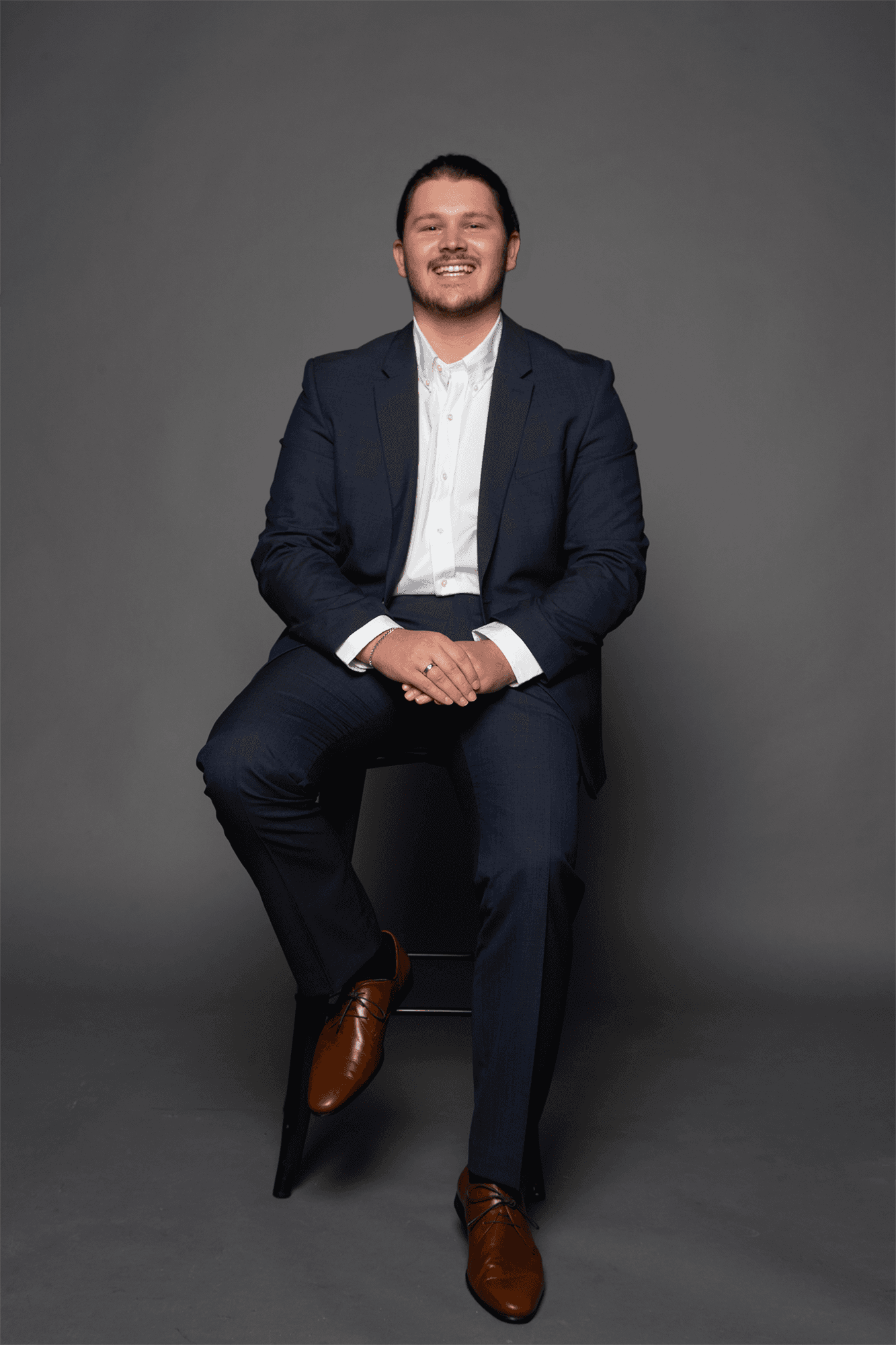 Louis Wright, Managing Partner of Wright Websites — full-length portrait in a navy suit against a neutral studio backdrop.
